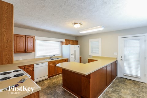 a kitchen with wooden cabinets and white appliances and a counter top