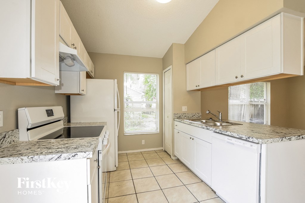 a kitchen with white cabinets and granite counter tops