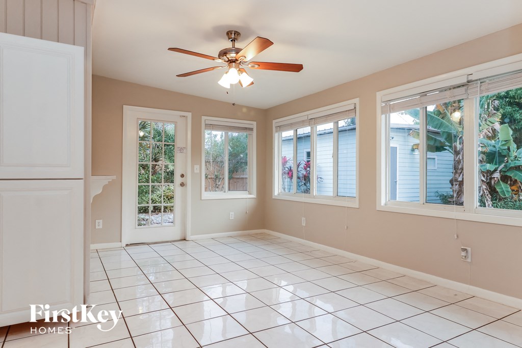 A spacious room with a ceiling fan and large windows.