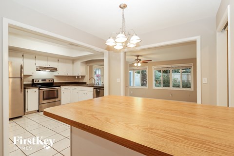 A kitchen with a wooden table and a chandelier.
