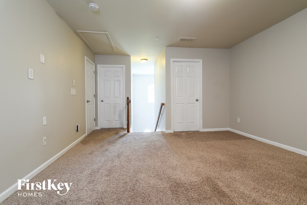 a empty living room with carpet and two doors