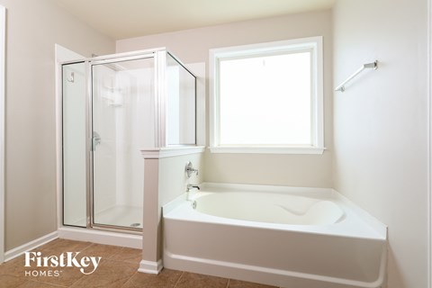 a white bathroom with a tub and a shower
