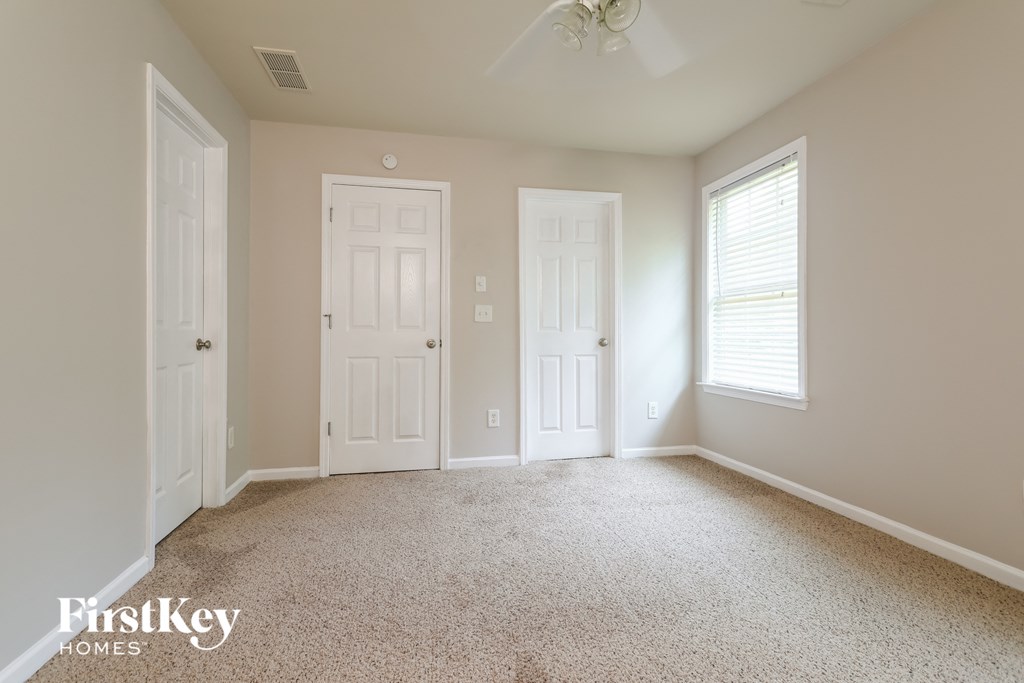 a bedroom with two white doors and a carpeted floor