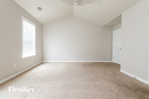 a bedroom with a carpeted floor and a window