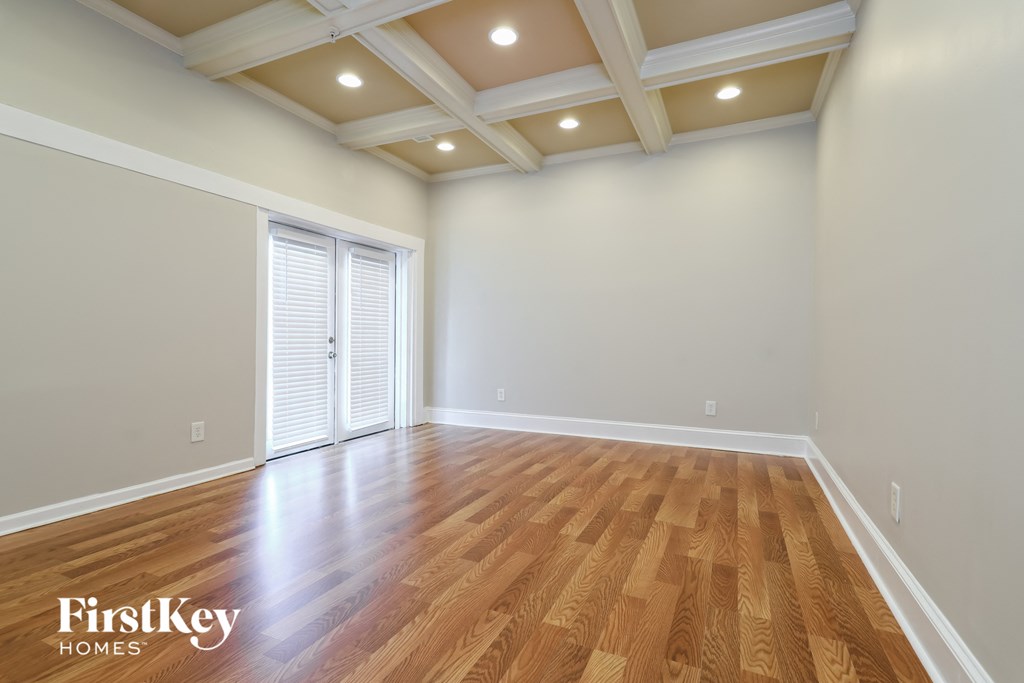 a living room with a hardwood floor and a coffered ceiling