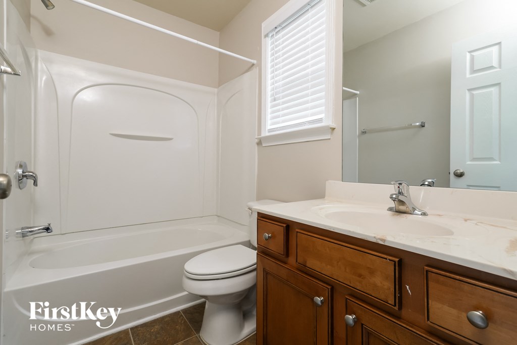 a bathroom with a toilet and a sink and a tub