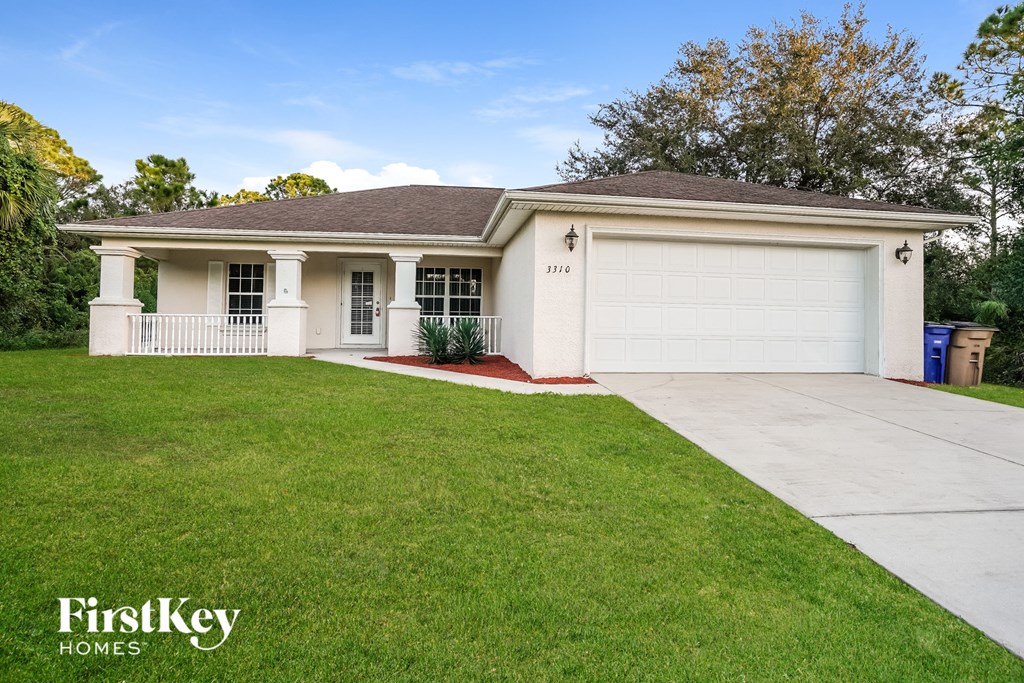 a white house with a driveway and a lawn