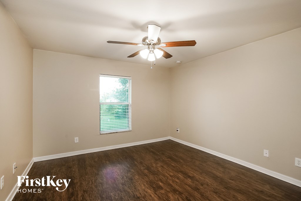 a living room with a ceiling fan and wood floors