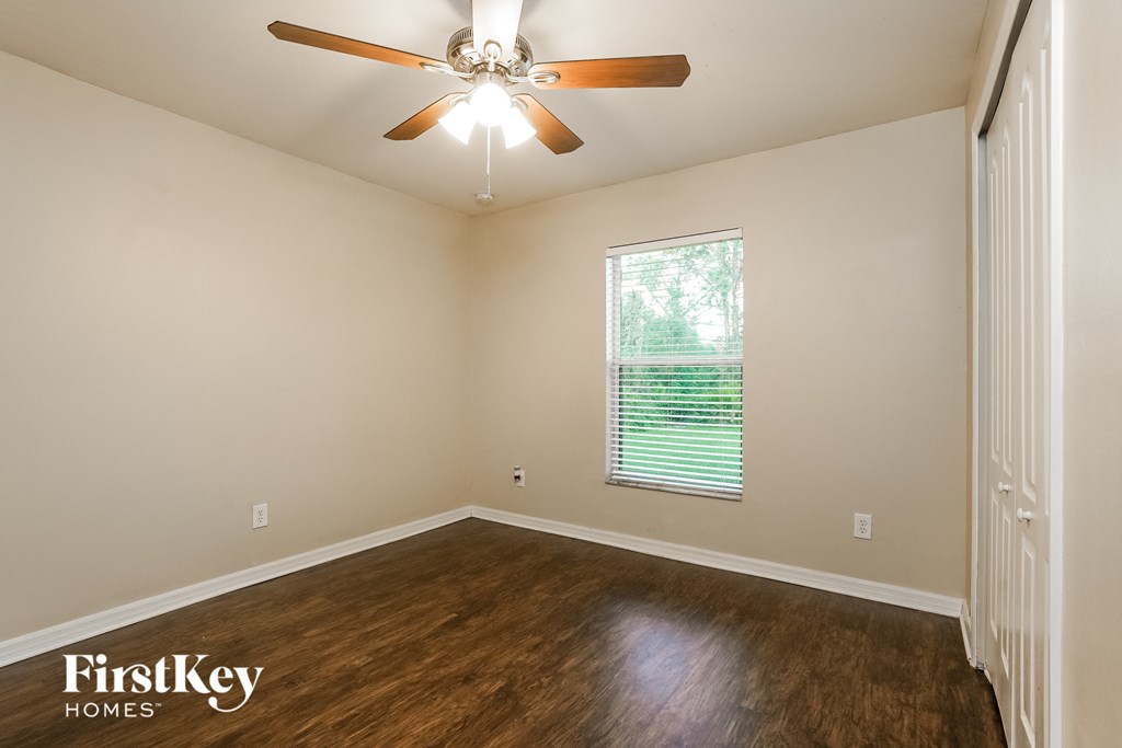 the living room of an empty house with a ceiling fan