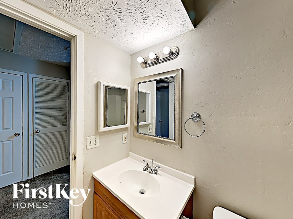 a bathroom with a sink and a mirror and a door