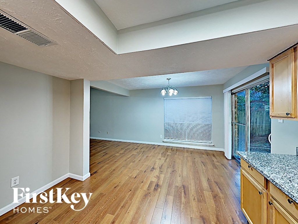 a kitchen and living room with wood floors and a sliding glass door