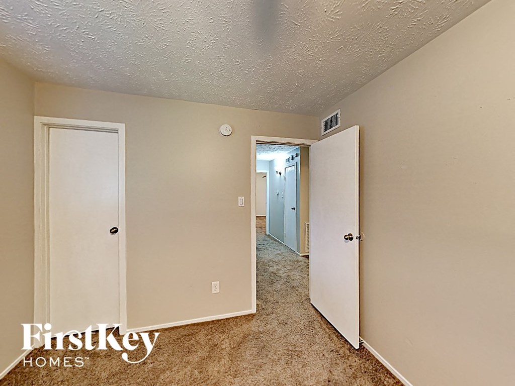 a bedroom with two closets and a hallway with two doors