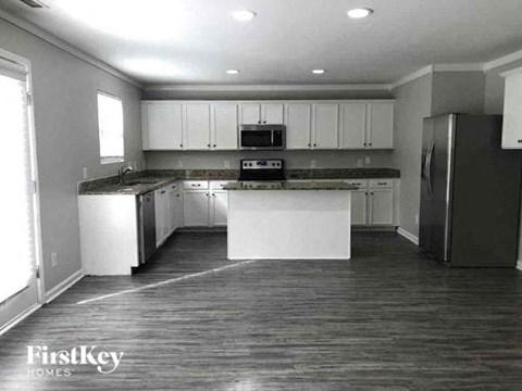 A kitchen with white cabinets and black appliances.