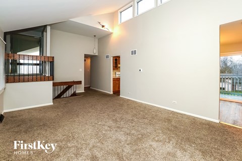 a living room with a carpeted floor and a balcony