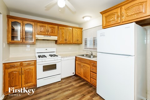 a kitchen with white appliances and wooden cabinets