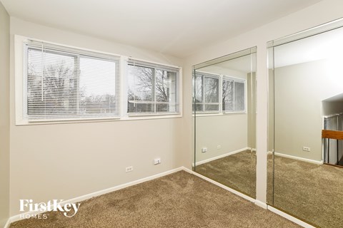 a bedroom with a large mirror and a carpeted floor