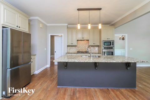 A kitchen with a granite countertop and stainless steel appliances.