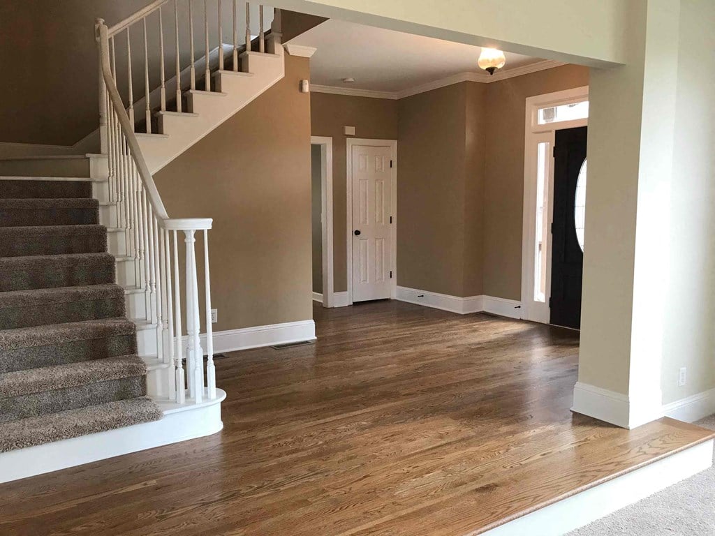 A staircase with a white railing leads to an upper level in a house.