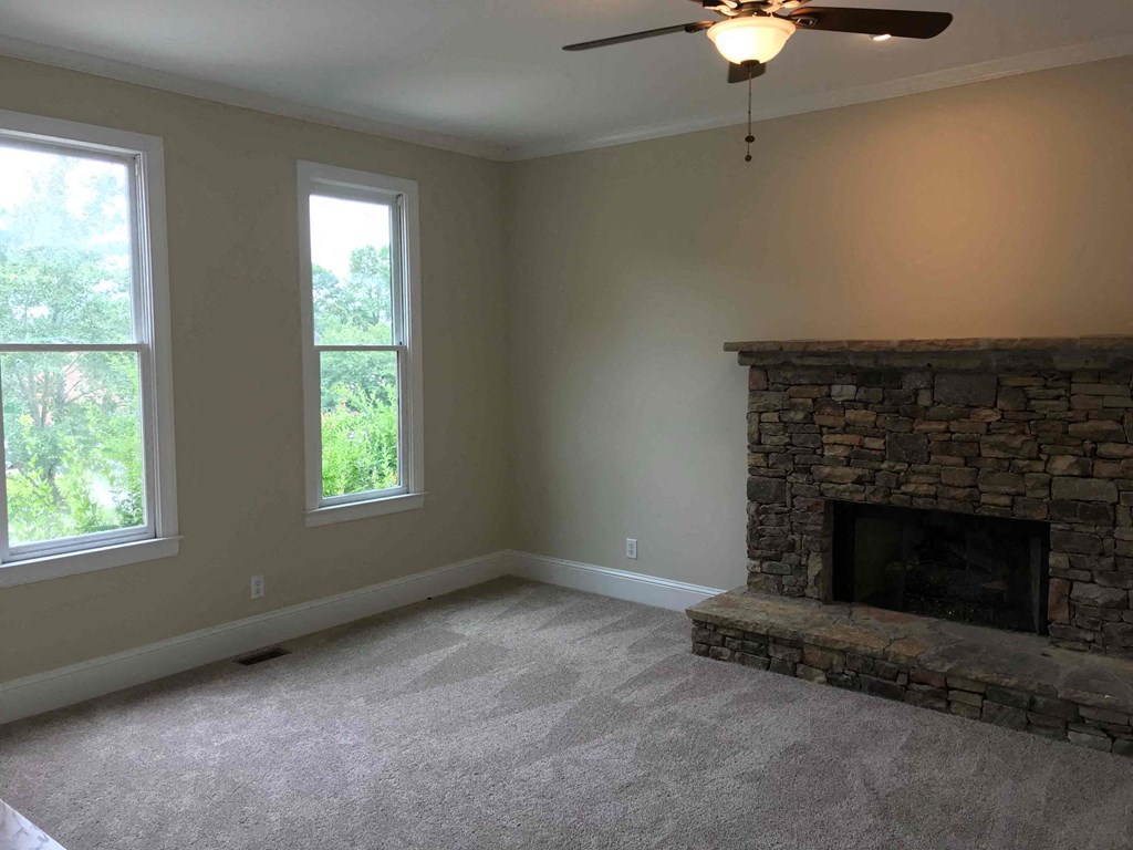 A room with a fireplace and a ceiling fan.