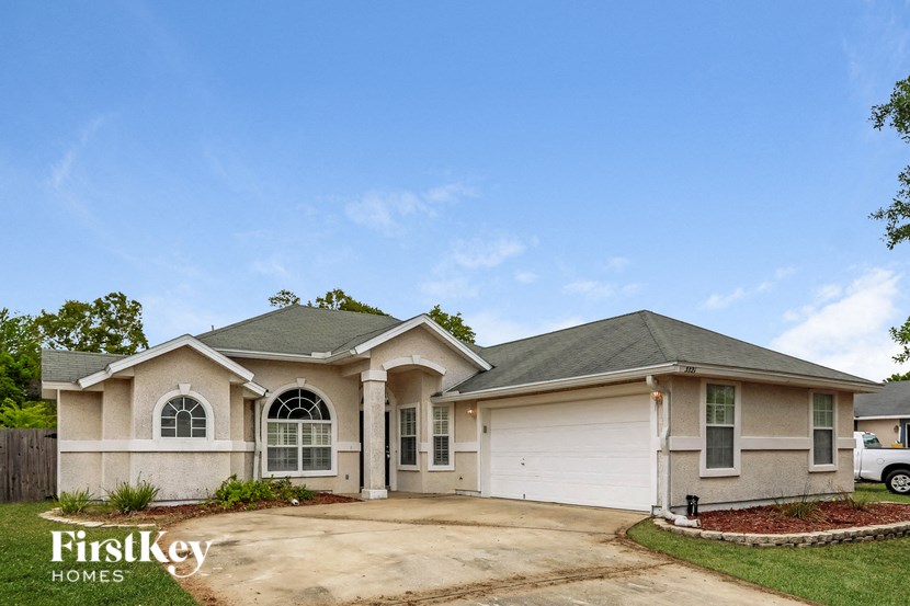 a beige house with a garage and a driveway