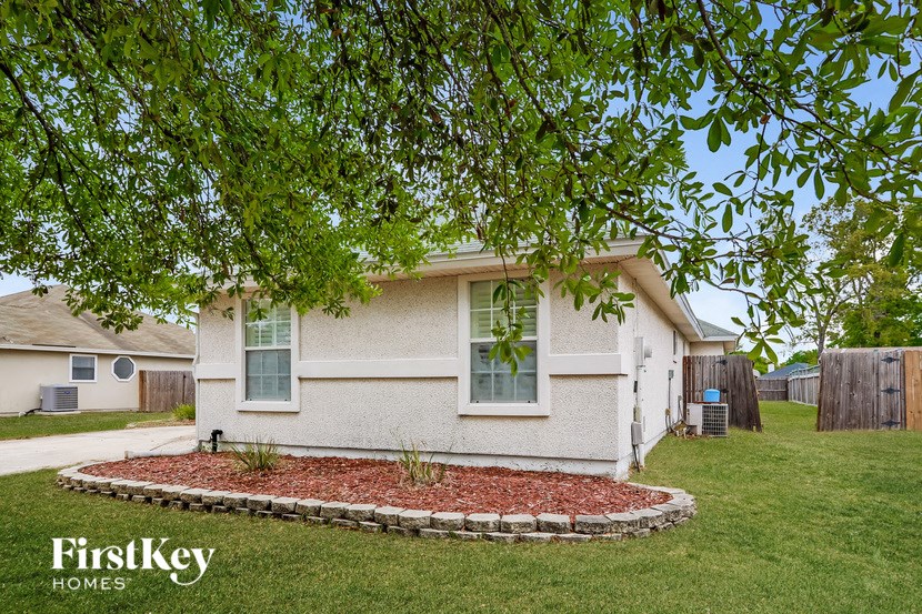 a white house with a yard and a tree