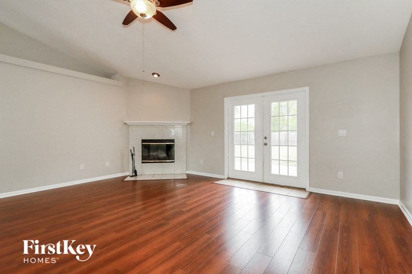an empty living room with wood floors and a fireplace