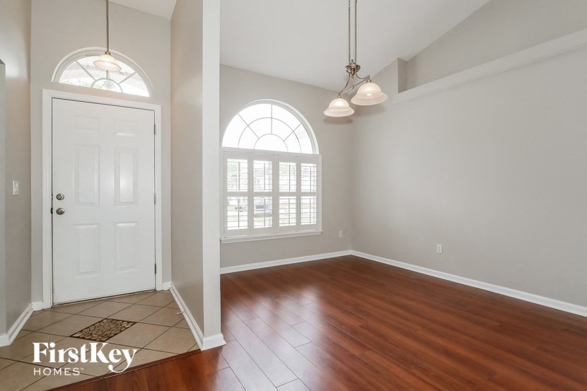 an empty living room with a white door and a window