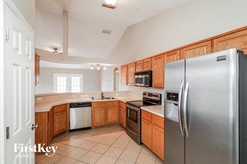 full view of kitchen with stainless steel appliances and wooden cabinets