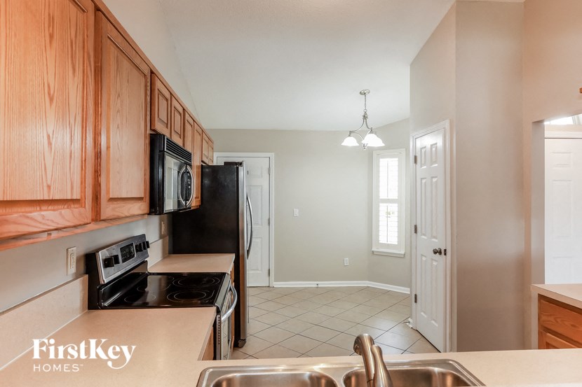 a kitchen with wood cabinets and black appliances and a sink