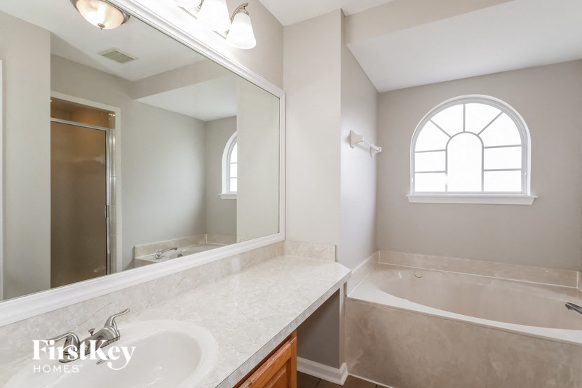a bathroom with a tub and a sink and a mirror