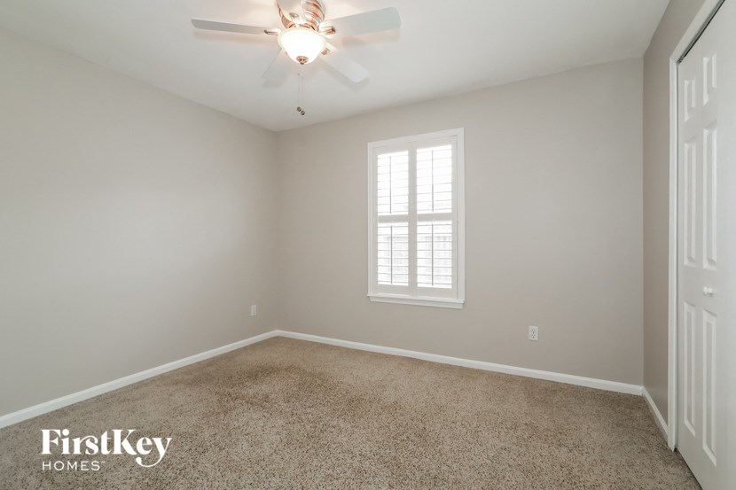 a empty room with a ceiling fan and a window