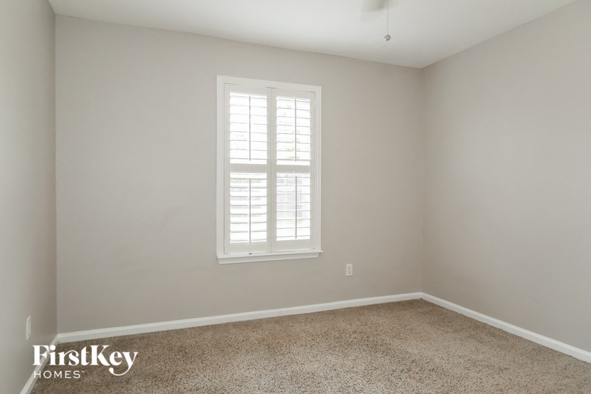 a empty room with a window and a carpet