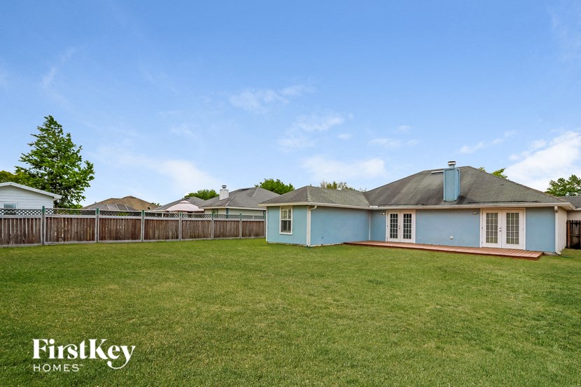 a blue house with a yard and a fence