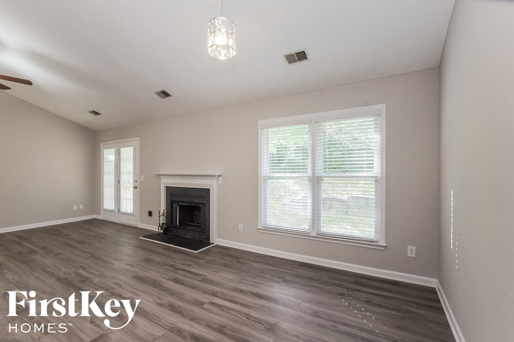 a living room with a fireplace and a large window