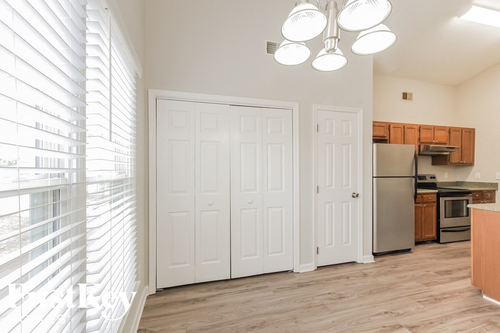 an empty kitchen with white doors and a window