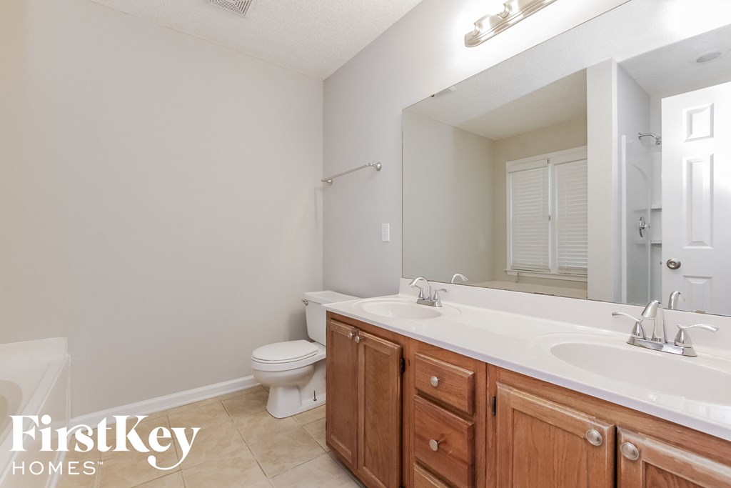 a bathroom with a large mirror and a sink and a toilet