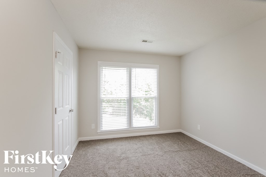 a bedroom with a large window and a white door