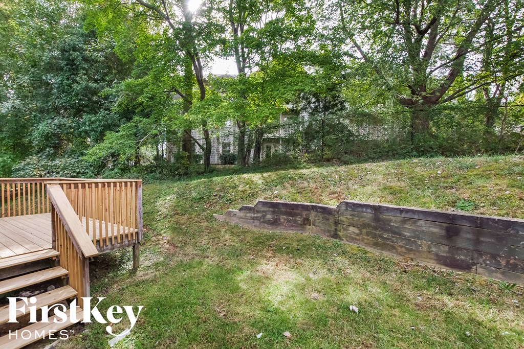a backyard with a wooden deck and a bench