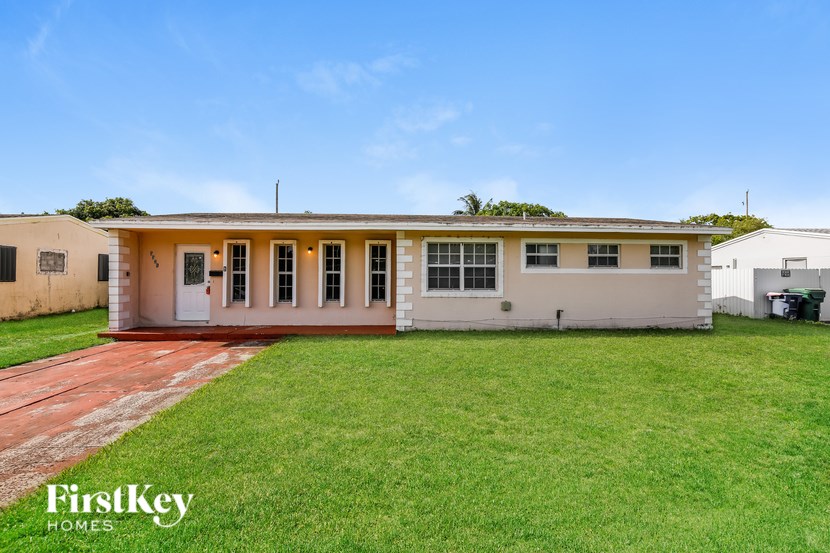 A house with a red brick pathway leading to the front door.