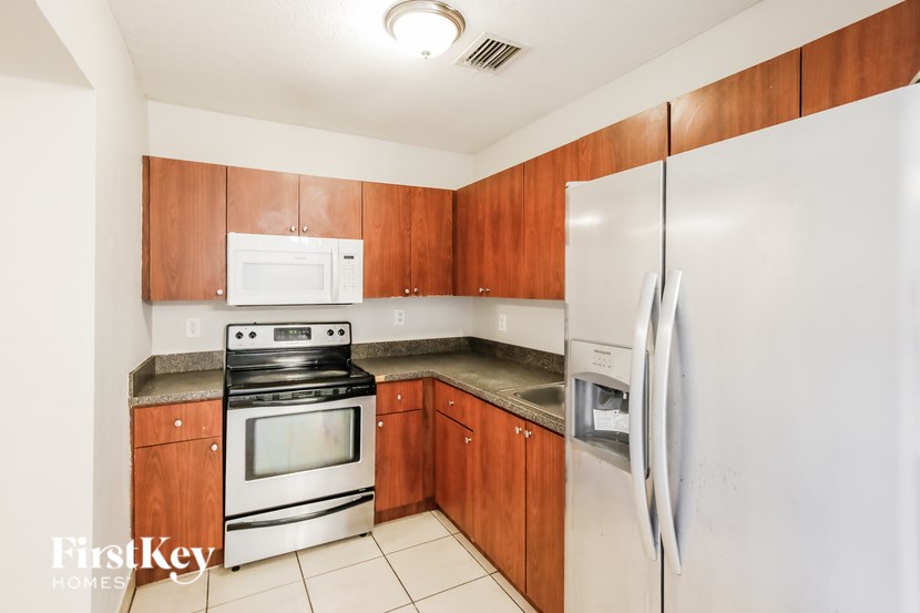 A kitchen with wooden cabinets and a white fridge.