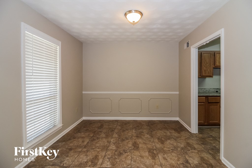 a dining room with a window and a door to a bathroom
