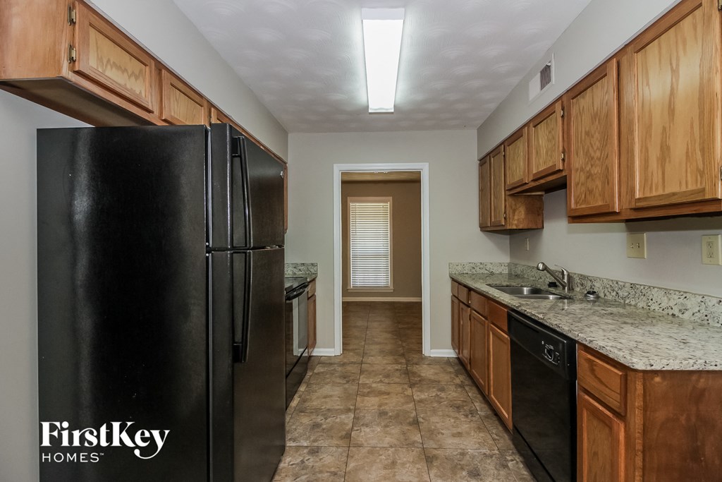 a kitchen with wooden cabinets and a black refrigerator