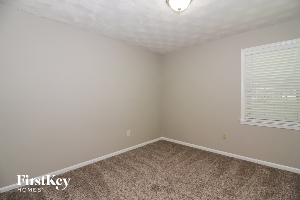 the upstairs bedroom with carpet and window