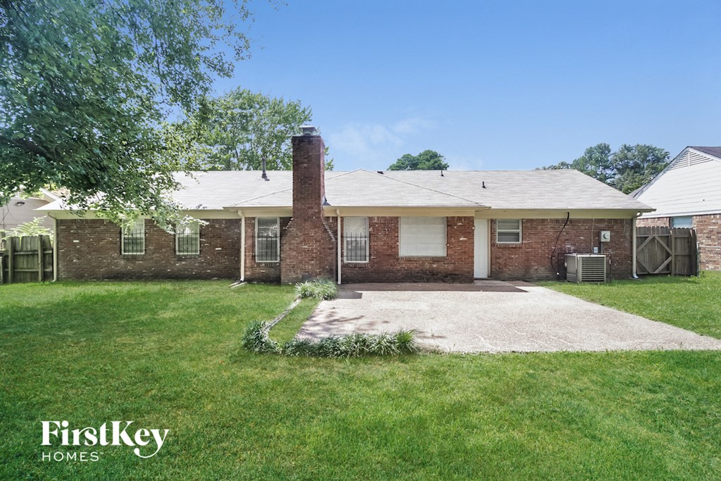 a brick house with a lawn and a driveway
