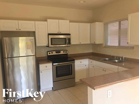 a kitchen with white cabinets and stainless steel appliances