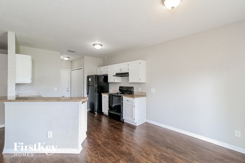 a kitchen with white cabinets and a black stove and refrigerator