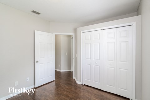 the living room of an apartment with white doors and wood floors