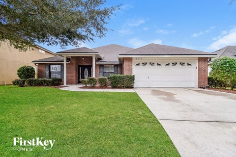a home with a white garage door and a lawn