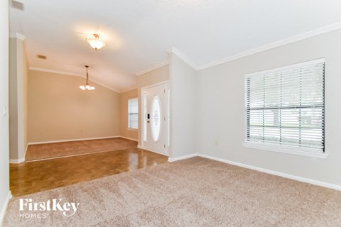the living room and dining room of an empty home