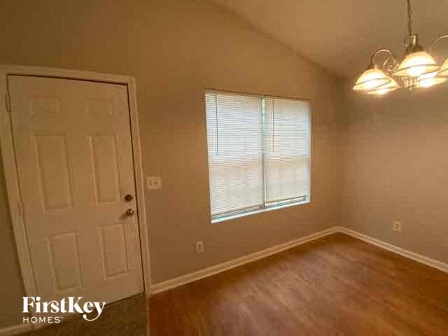 A room with a door, a window with blinds, and a light fixture.